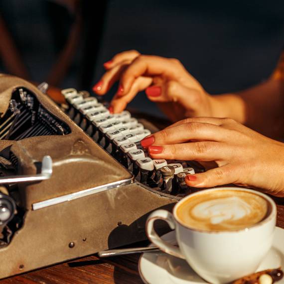woman typing with coffee foto