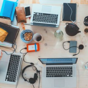 birds eye view of desk with handheld devices and laptops