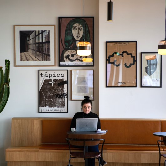 female freelancer working on laptop in empty cafe