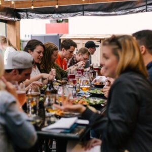 people sitting at a table talking and eating