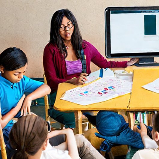 Ai generated image of a teacher and students and a computer monitor