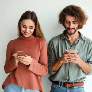 a man and a woman looking at their phones