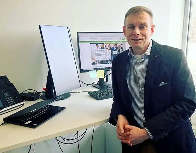 Warren Laine-Naida standing at his desk