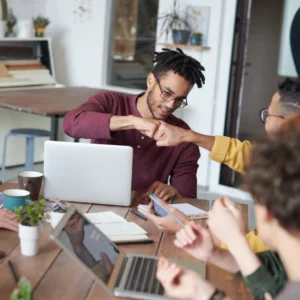 men bumping fists at office table