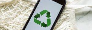 smartphone-with-recycling-sign-on-screen-placed-on-white-mesh-bag-on-marble-table