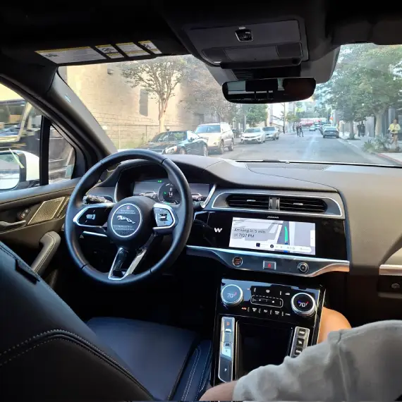 inside of a waymo car driving down the street